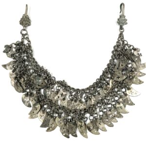 Traditional jewelry with double chain and decorative cross pendant.
