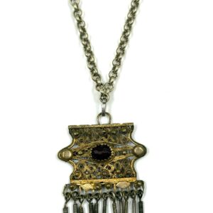 Traditional filigree pendant with central red decorative stone.